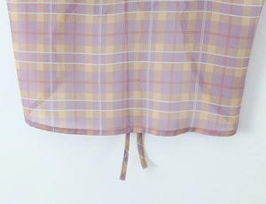 Dettaglio del tessuto in chiffon a quadri lavanda e giallo con coulisse sull'orlo