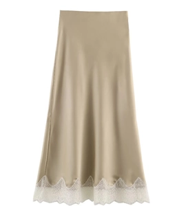 Detail of champagne satin midi skirt with delicate white lace trim on the hemline