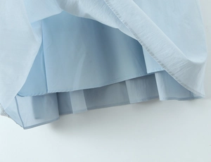 Close-up of light blue pleated skirt hem showing high-quality stitching and inner lining