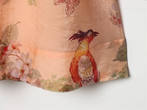 Detailed view of floral silk fabric with butterfly print and smooth hem stitching