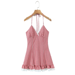 Close-up of red plaid halter dress featuring delicate white lace trim and V-neckline