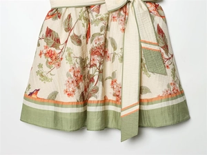 Détail d'imprimé floral et oiseaux sur robe en lin et coton avec ourlet coloré cousu