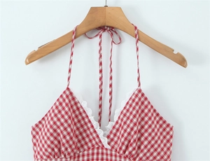 Close-up of red and white plaid halter dress with delicate white lace trim on V-neckline