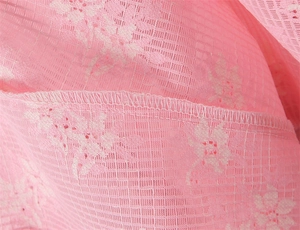 Vista macro dettagliata del pizzo floreale rosa con cuciture overlock professionali