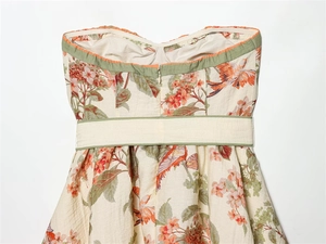 Détail d'une robe bustier avec imprimé floral, bordure verte et fermeture éclair invisible