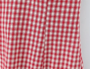 Detailed macro view of red and white checkered fabric with visible stitching and texture