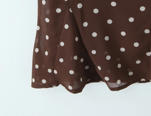 Gros plan sur tissu marron à pois blancs montrant une texture légère et transparente