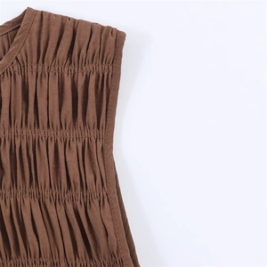 Detailed close-up of brown pleated fabric with vertical textures and refined stitching