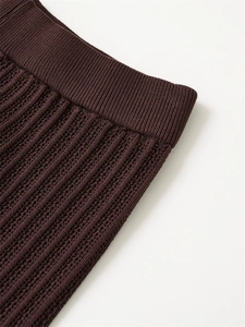 Detailed close-up of dark brown knit fabric showing ribbed waistband and fine vertical texture