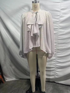 Détail d'un chemisier à pois pour femme avec col à volants et nœud papillon élégant