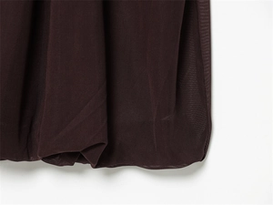 Détail du tissu en maille marron foncé montrant la texture fine et la matière aérée