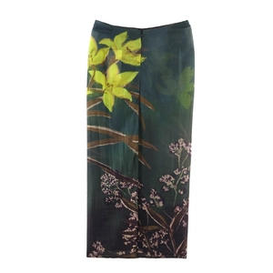 Détail d'une élégante jupe midi vert foncé avec des motifs floraux de lys jaunes vifs