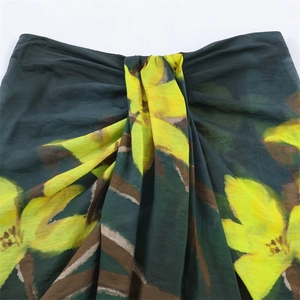 Vue détaillée de la jupe à fleurs vert foncé avec imprimés jaunes et texture plissée
