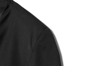 Close-up of shoulder stitching and textured woven fabric on a slim fit black blazer
