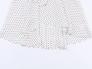 Détail de l'ourlet à volants superposés et motif à pois sur la jupe en mousseline