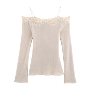 Detail of off-shoulder beige knit top with delicate lace trim and thin straps