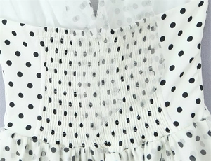 Detailed view of polka dot mesh fabric with smocked elastic waist for a slim fit design