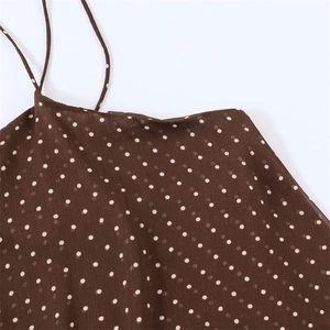 Detail of dark brown polka dot fabric and thin strap showing high-quality textile texture