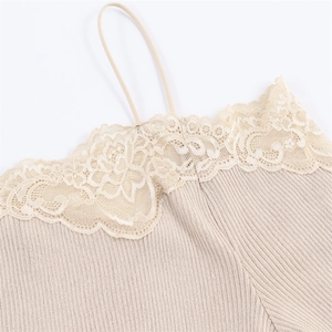 Detailed view of beige ribbed knit fabric with delicate lace trim and fine shoulder strap