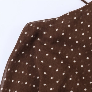 Close-up of semi-transparent brown chiffon fabric featuring a white polka dot print pattern