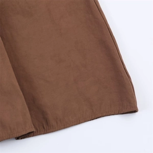 Brown midi dress hem with detailed stitching on smooth synthetic fabric