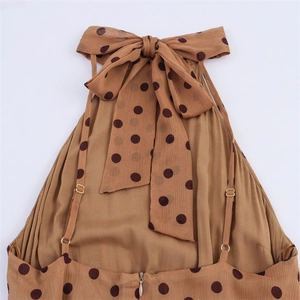 Detail of the halter neckline with a large bow and adjustable straps on a polka dot dress