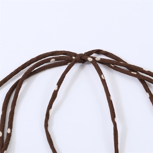 Detailed view of the brown polka dot dress featuring a stylish neck tie and chiffon texture