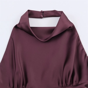 Detail eines eleganten Satin-Halterneck-Kleids mit anspruchsvollem Wasserfallausschnitt