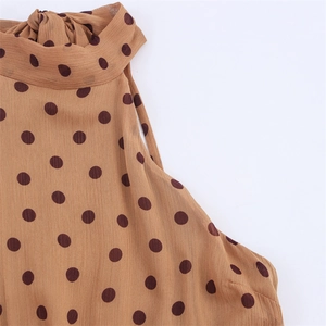 Detailed macro shot of the halter neck tie and brown polka dot chiffon fabric texture