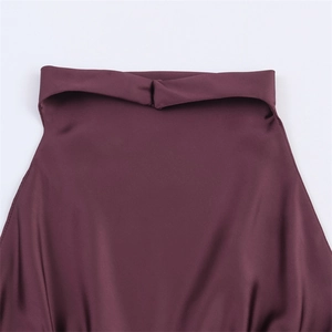 Detail des eleganten Neckholder-Knotens an einem seidigen Kleid in Dunkellila