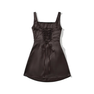 Detail of chocolate brown satin corset dress featuring cross back lace-up design