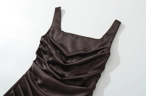 Detail of dark chocolate satin mini dress featuring elegant ruching and square neckline