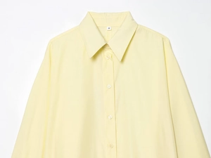 Detail of light yellow poplin shirt collar and button placket with neat stitching