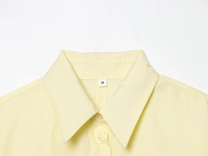 Close-up of pale yellow cotton poplin shirt collar with white size S label inside