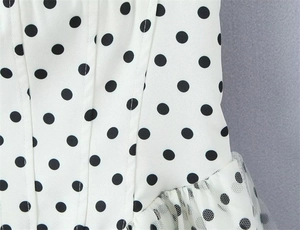 Detailed view of the polka dot pattern mesh hem and vertical seams on this white dress