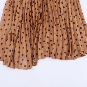 Detailed view of lightweight pleated khaki chiffon fabric with dark brown polka dots