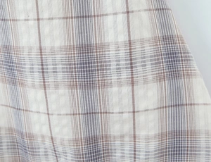 Gros plan sur un tissu à carreaux rétro avec détails de tissage marron et gris