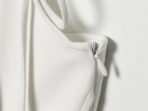 Detail of the white tulle shirt showing a seamless invisible zipper and woven texture