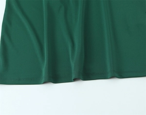 Détail de l'ourlet à double surpiqûre sur la robe midi en maille vert foncé