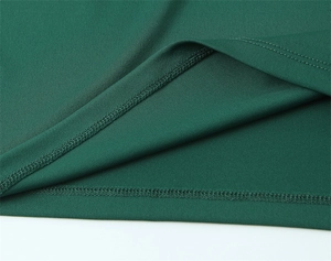 Gros plan détaillé de la double couture de qualité sur une robe midi en maille vert foncé