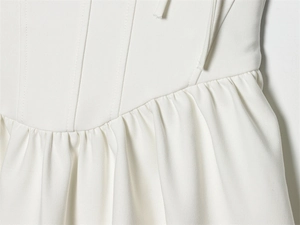 Detail of white corset waist blouse with structured bone lines and delicate pleats