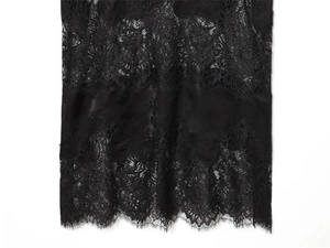 Detailed macro view of black floral embroidery lace fabric with eyelash lace trim edge