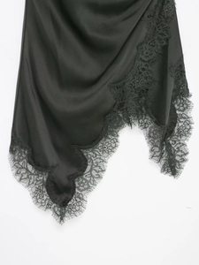 Détail de l'ourlet en satin noir avec dentelle florale raffinée et bords irréguliers de robe