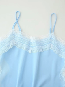 Detail of light blue camisole featuring delicate white lace trim and thin spaghetti straps