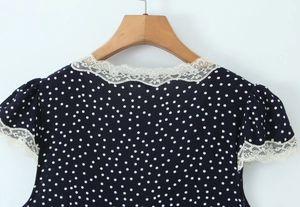 Detail of navy blue polka dot top with white lace trim on the V-neck and shoulder