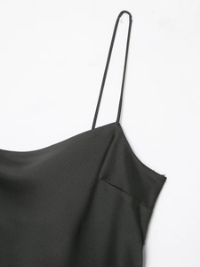 Détail de la robe noire à fines bretelles spaghetti montrant la texture du tissu délicat
