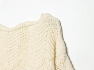 Gros plan sur le pull en maille blanc crème avec motif crochet ajouré ondulé