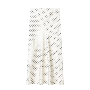 Detailansicht der glatten Satin-Stofftextur und des klassischen Polka-Dot-Musters am Rock