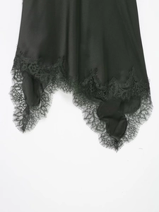Détail de l'ourlet d'une robe en satin noir orné d'une dentelle de cils raffinée