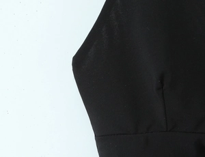 Détail de la texture du tissu noir et des coutures de l'ensemble jupe à pois